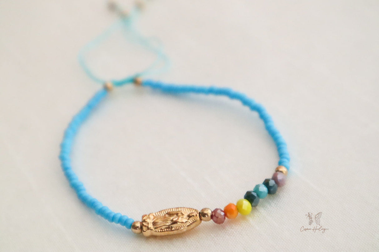 Charming blue thread bracelet with Seven Chakra beads and Guadalupe pendant