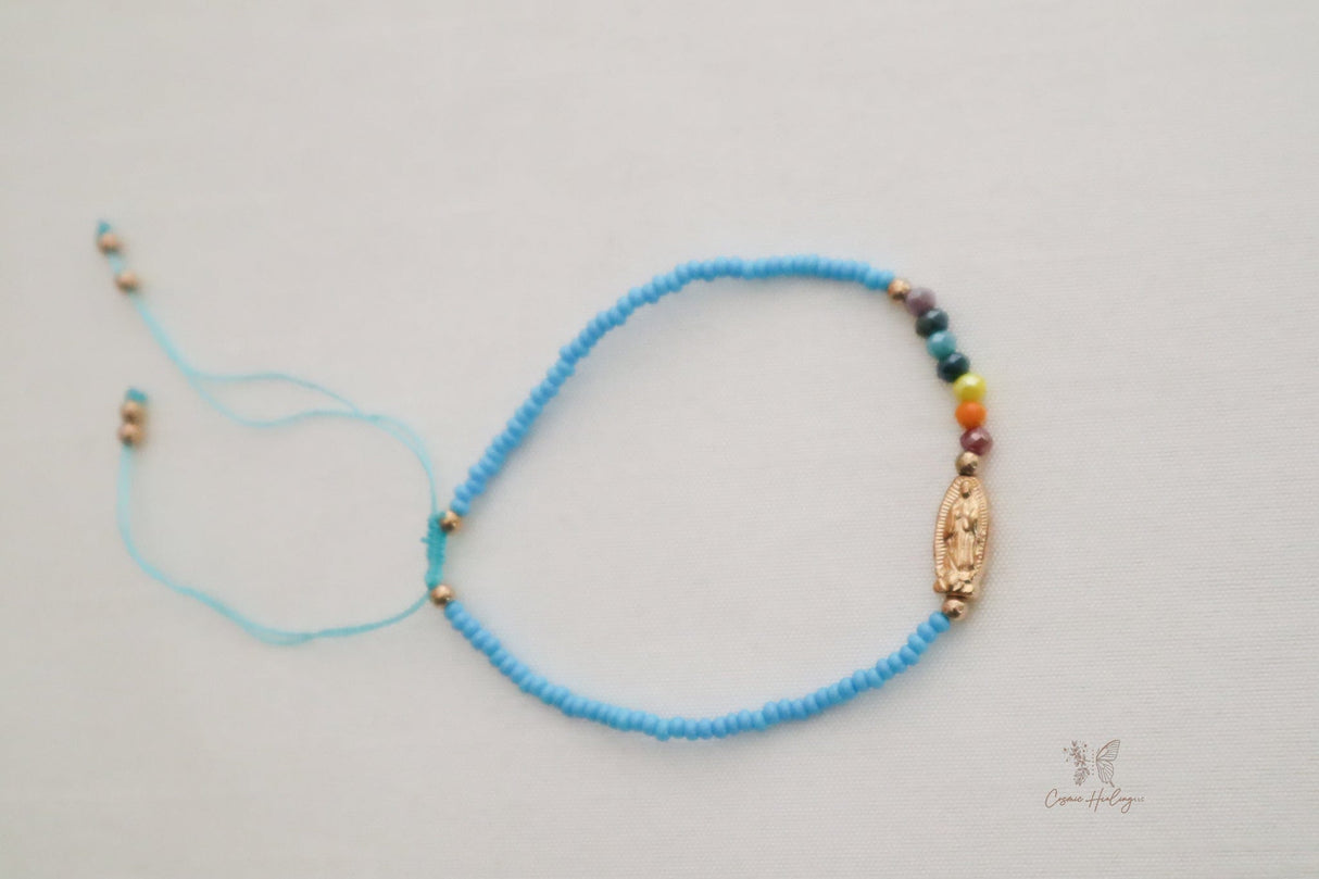 blue thread bracelet featuring Seven Chakra and Guadalupe charm