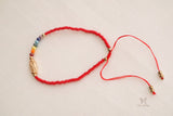 Red thread bracelet featuring Seven Chakra stones and Guadalupe